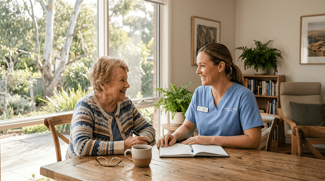 An aged care worker smiling with an elderly woman at a table in a bright Australian home